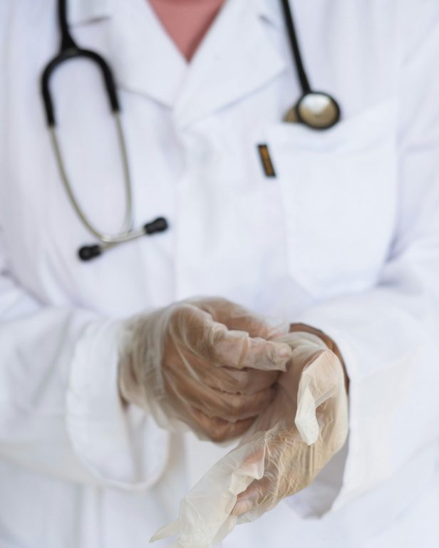 pexels photo 3825586 3825586 Faceless ethnic medical worker in lab coat and stethoscope taking of transparent gloves after approaching patients for examination in modern hospital